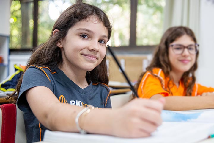 Aluna organizando a rotina com agenda e livros didáticos